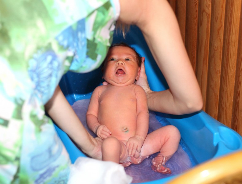 a 6-day old baby boy taking his first bath
