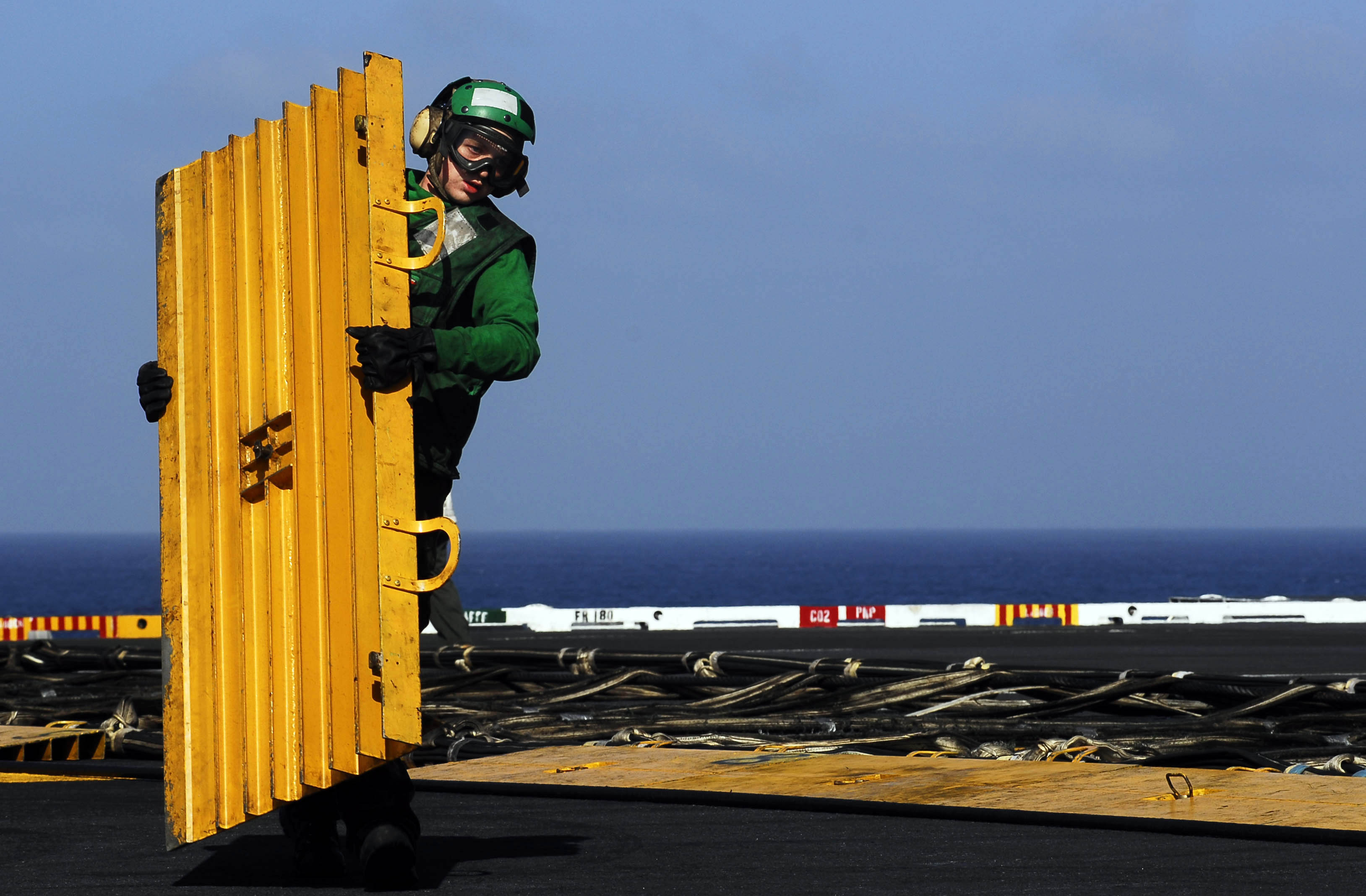 US Navy 081010-N-9928E-042 Aviation Boatswain's Mate (Equipment) Airman Zach Hill removes a barricade deck ramp