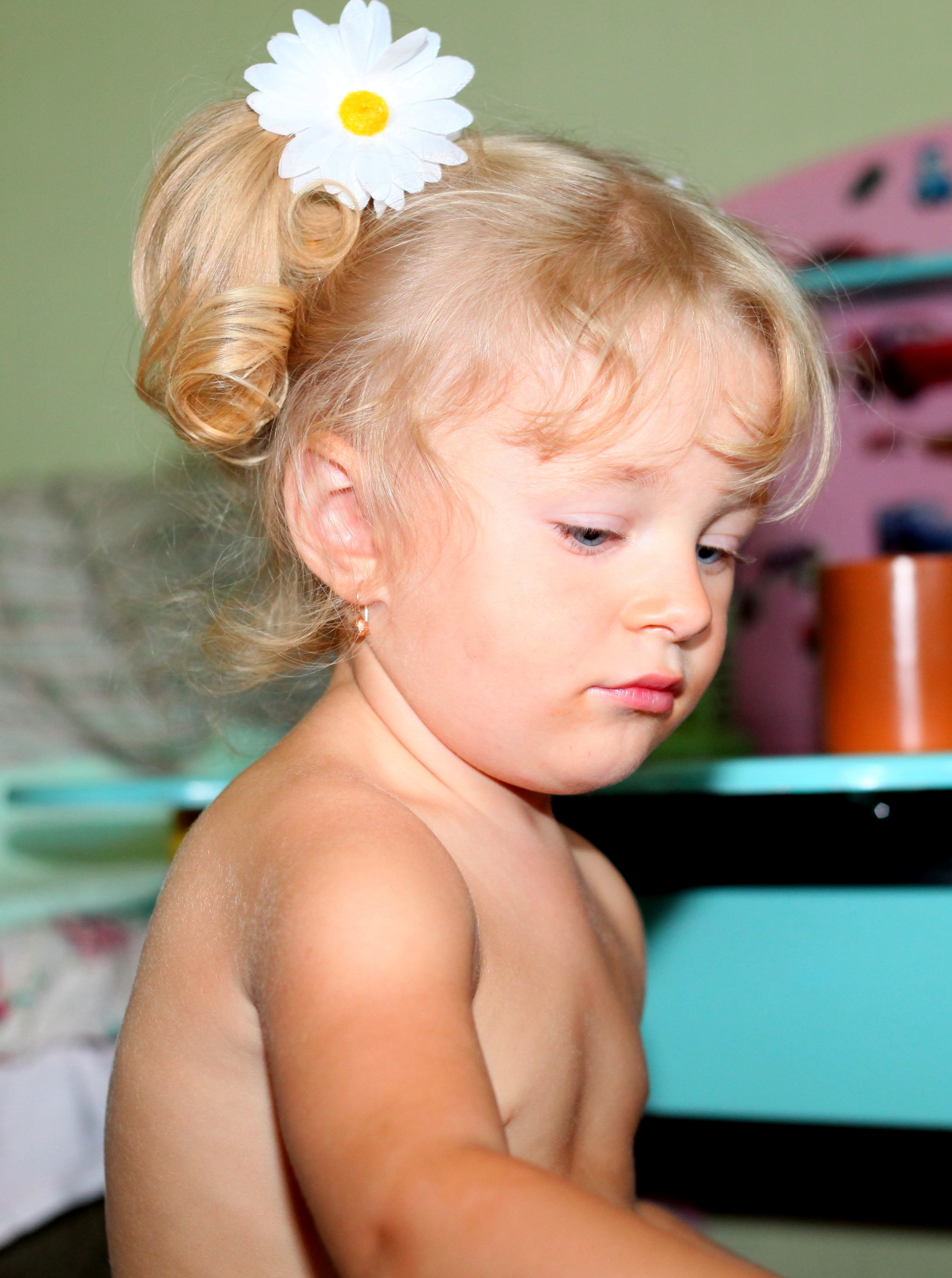 a cute blond baby girl with a white flower in her hair