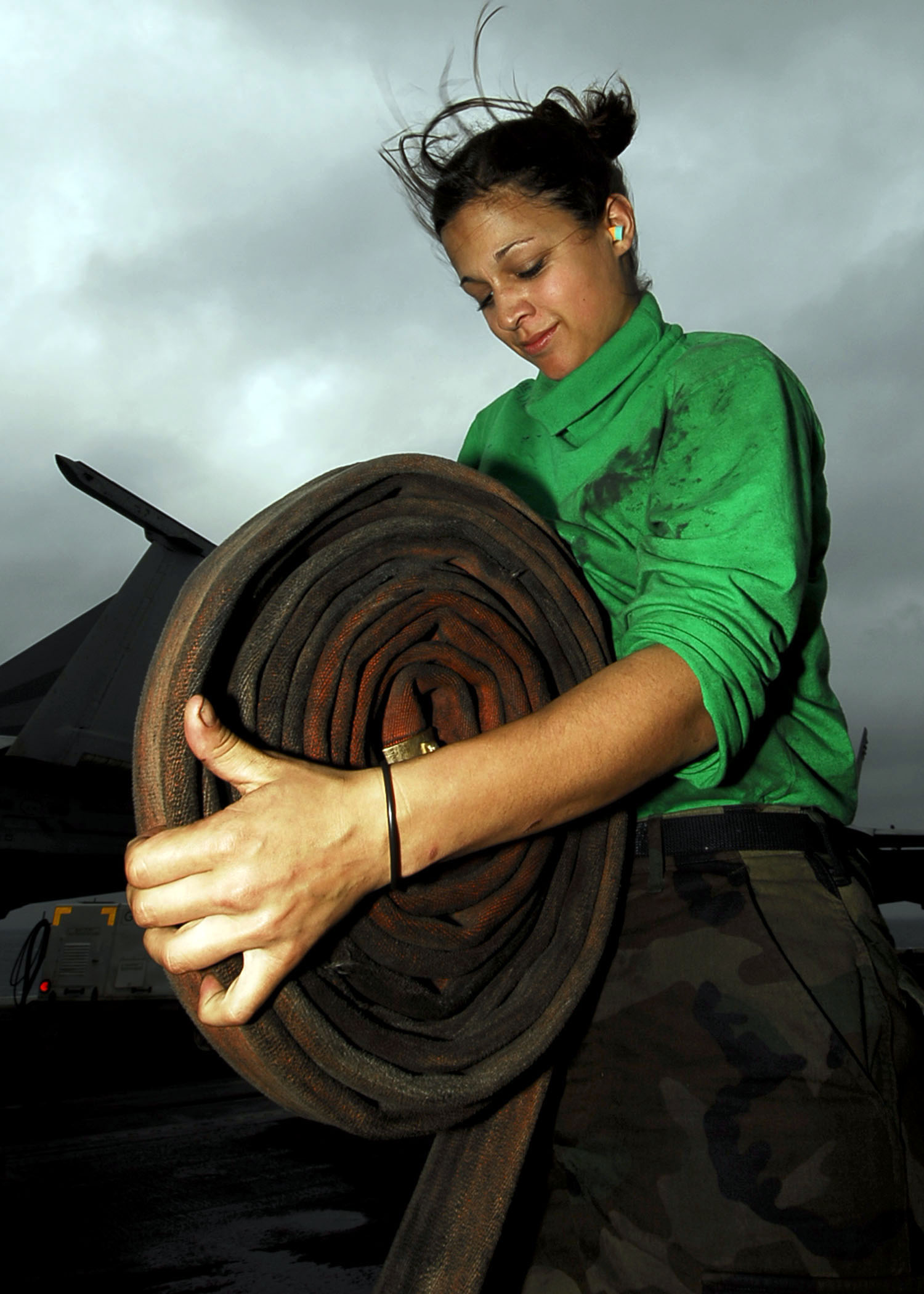 US Navy 090216-N-6538W-205 Aviation Boatswain's Mate (Equipment) Airman Apprentice Angela Fuga, from St. Clair, Mich., rolls a hose after cleaning catapult deck plates aboard the Nimitz-class aircraft carrier USS John C. Stenni