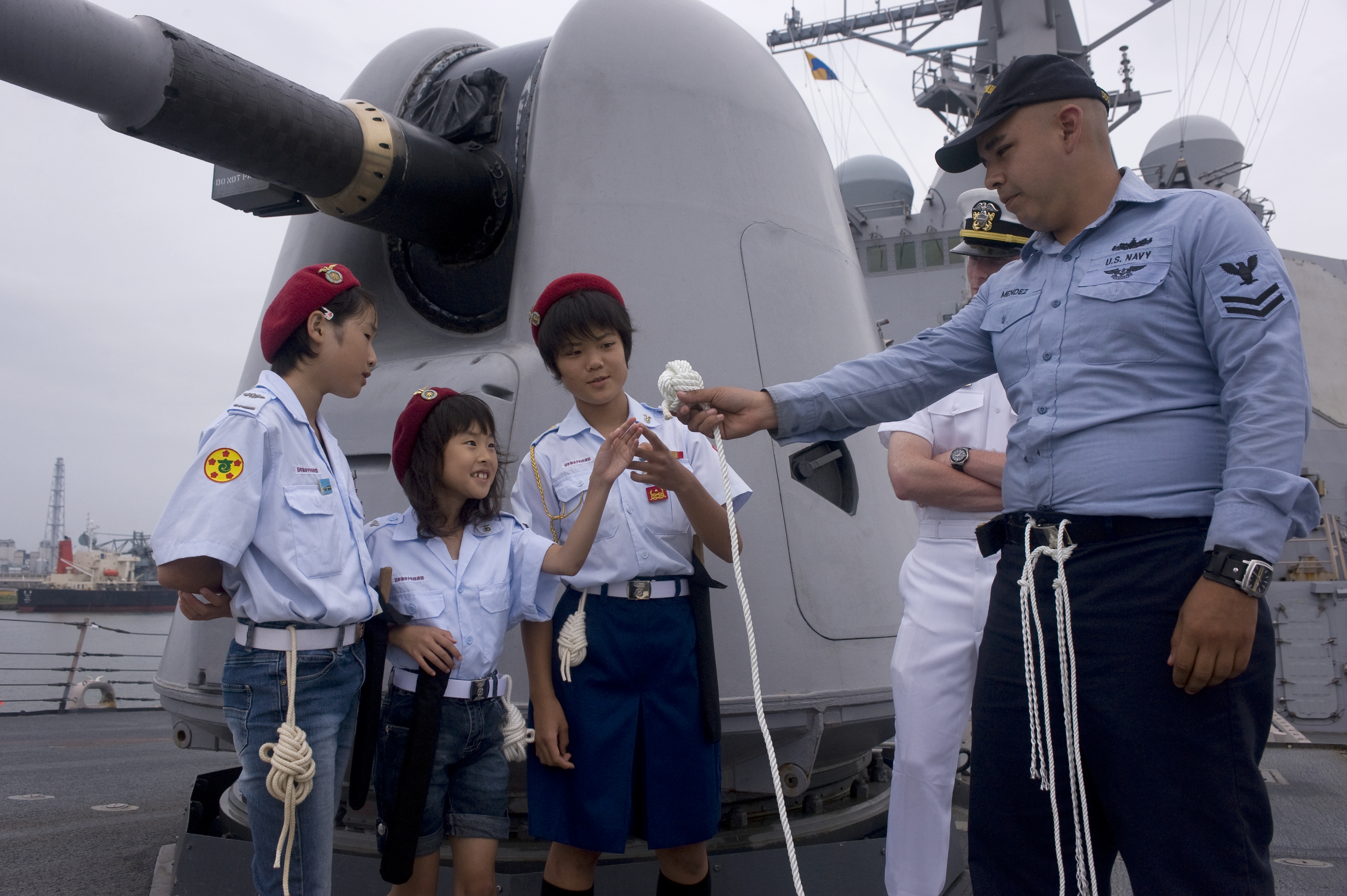 US Navy 100105-N-3333H-001 Boatswain's Mate 2nd Class Anthony Ryan Mendez demonstrates knot-tying techniques to Japanese sea cadets during a tour aboard the guided-missile destroyer USS Curtis Wilbur (DDG 54)